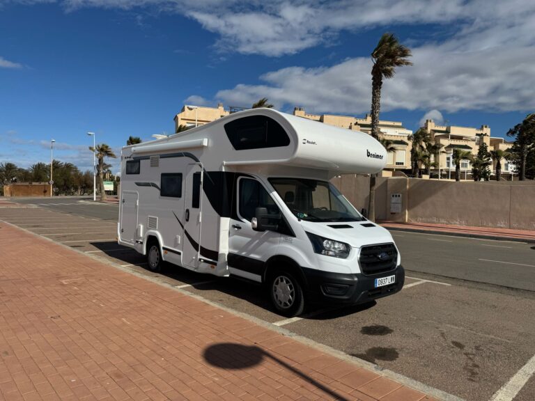 Autocaravana capuchina Benimar de alquiler aparcada junto a palmeras
