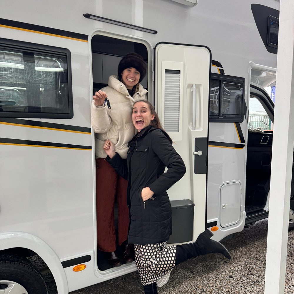Marta y Helena, de HappyKaravan, en la puerta de una autocaravana de alquiler con las llaves en la mano